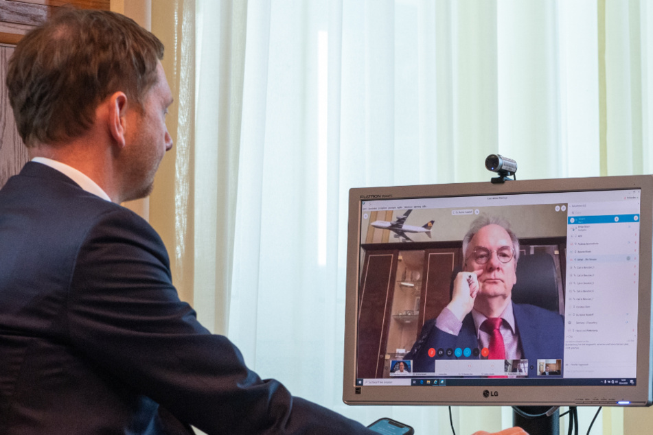 Dresden, Mitte April: Michael Kretschmer (44, CDU), Ministerpräsident von Sachsen, sitzt in einem Büro in der Staatskanzlei vor einem Computerbildschirm und spricht während einer Schaltkonferenz per Video mit Reiner Haseloff (66, CDU), Ministerpräsident Sachsen-Anhalt.