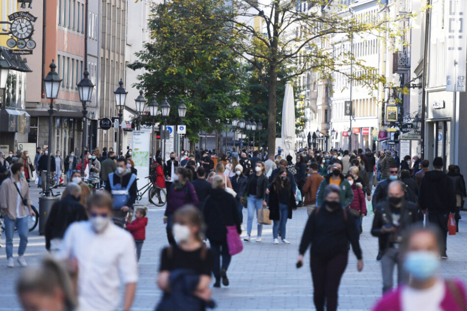 Passanten bummeln mit Mundschutz durch die Münchner Innenstadt.