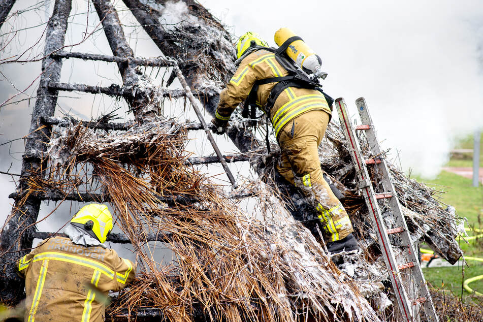 Einsatzkräfte der Feuerwehr löschen den Brand auf dem Schulgelände.