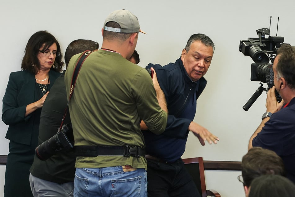 US Senator Alex Padilla (2nd from R.), Democrat from California, is removed from the room after interrupting a news conference with Department of Homeland Security Secretary Kristi Noem at the Wilshire Federal Building in Los Angeles on Thursday.
