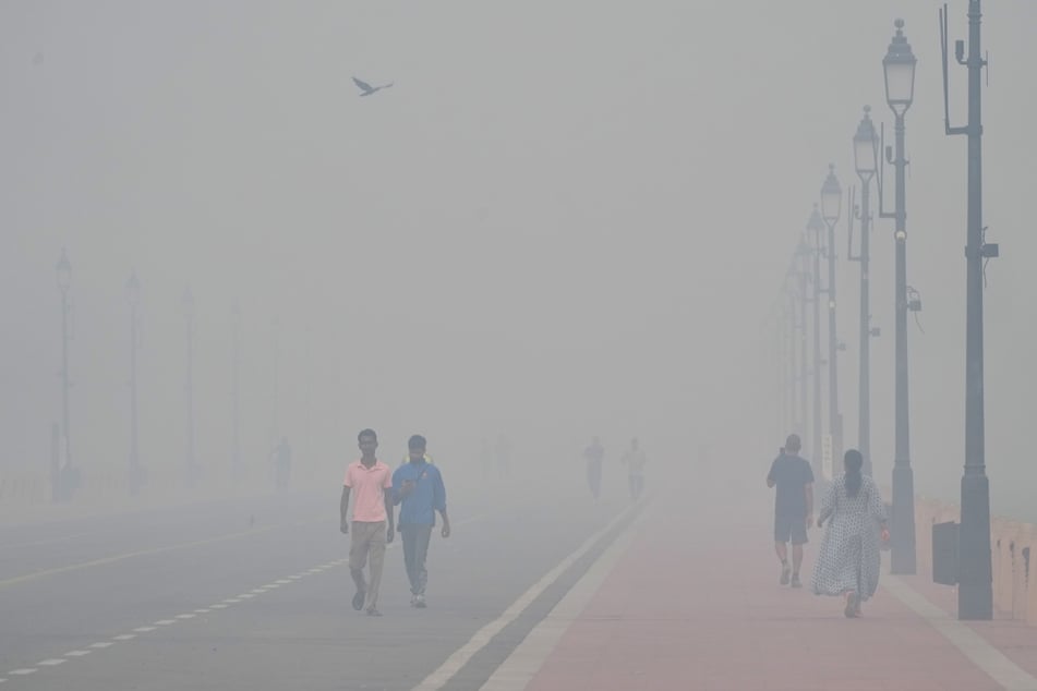Menschen spazieren in der Nähe des India Gate Monument einen Tag nach dem Diwali-Fest.