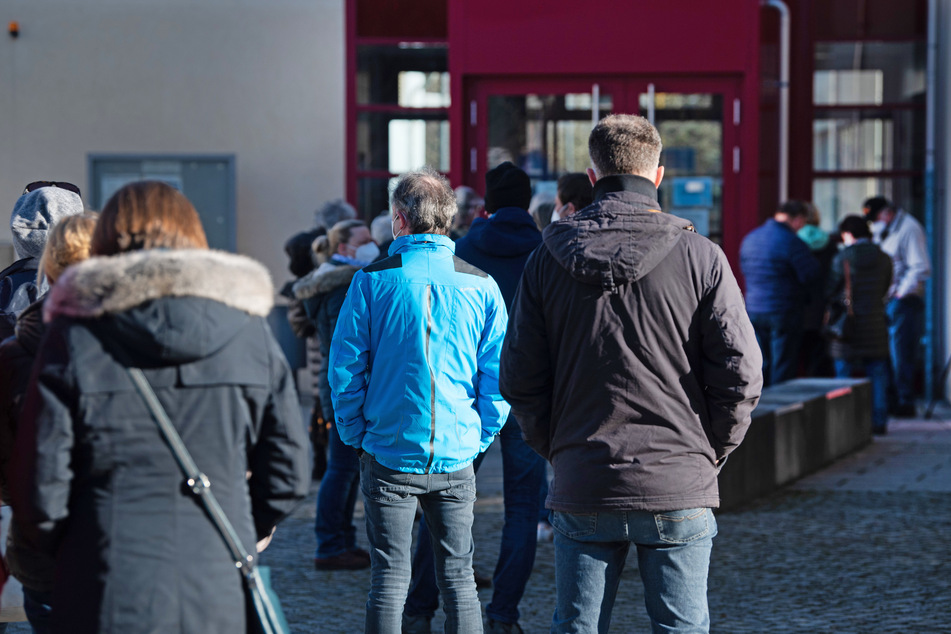 Bewohner der Region warten vor der Sporthalle des Berufsschulzentrums Radeberg auf den Beginn eines Massentests.