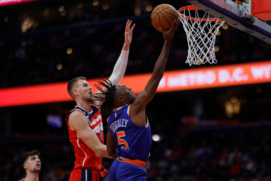 New York Knicks guard Immanuel Quickley (r.) goes for the basket against Washington Wizards center Kristaps Porzingisdefends at Capital One Arena on Friday night.