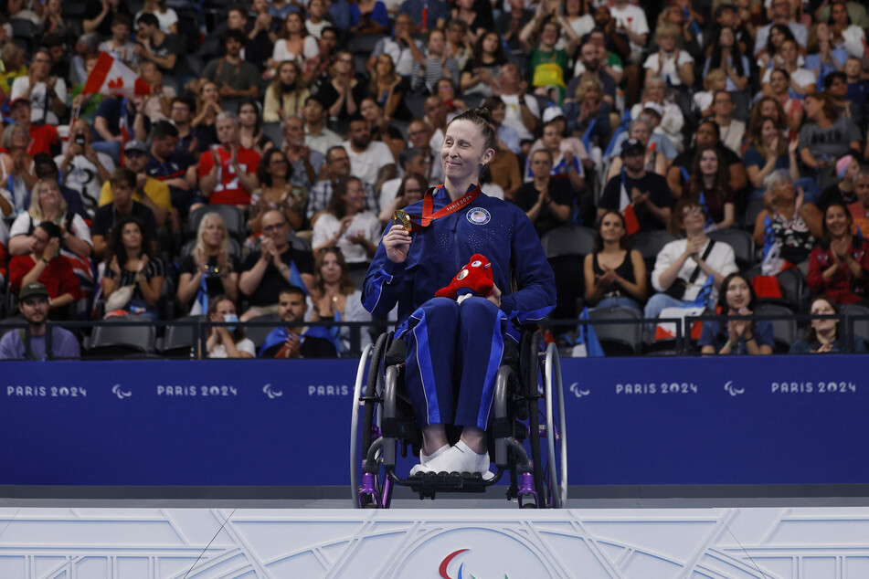 Leanne Smith of Team USA celebrates on the podium after winning the gold medal in the 100m freestyle S3 at the Paris Paralympics.