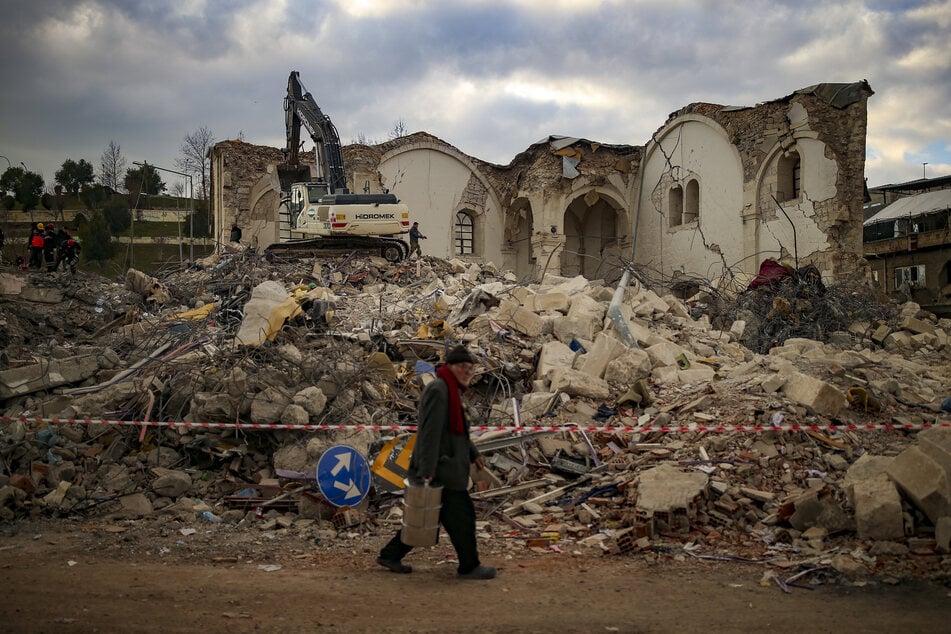 Ein Mann geht an einem eingestürzten Gebäude in der türkischen Stadt Asuyaman vorbei.