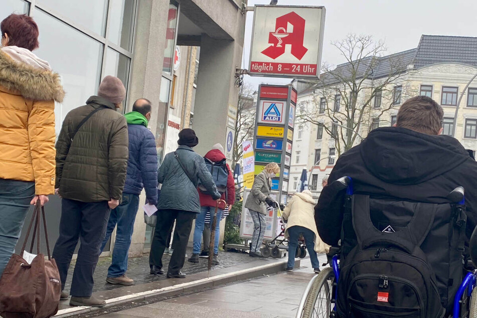 Vor einer Apotheke im Stadtteil Eimsbüttel warten Menschen.