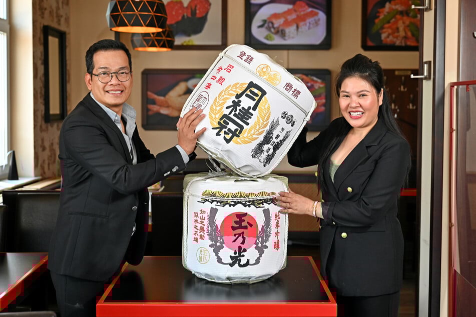 Van Giang Phan (45) und Thi Hanh Ha (46) zeigen einen traditionellen Sake-Behälter.