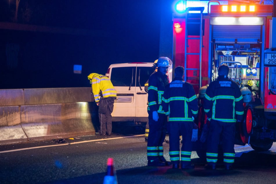 Einsatzkräfte der Feuerwehr stehen an der Unfallstelle auf der A1 in Hamburg.