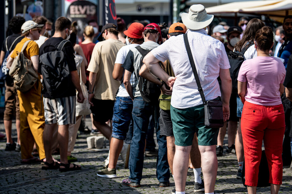 Menschen warten in der Schlange eines mobilen Impfteams auf dem Hermannplatz.