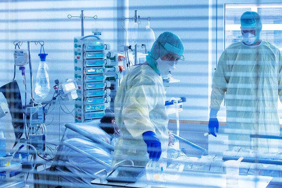 Mediziner versorgen einen an Covid-19 erkrankten Patienten – die Intensivbetten-Belegung in Hessen ist erneut leicht gesunken.