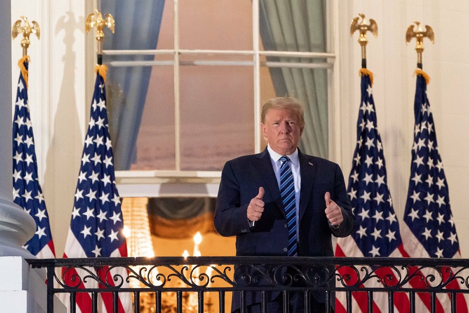 Ex-president Donald Trump gives a thumbs up to supporters after his discharge from Walter Reed hospital following his Covid-19 infection.