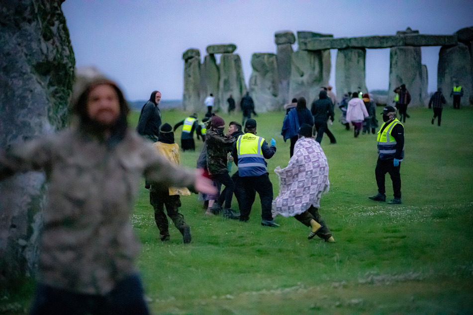 Menschen sprangen in den frühen Morgenstunden über einen Zaun und bahnten sich ihren Weg an Sicherheitspersonal vorbei in Richtung Stonehenge.