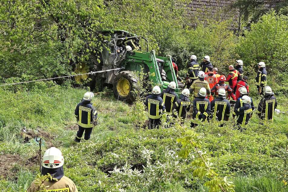 Nach einem rund 40 Meter tiefen Sturz kam der Traktor an einem Baumstamm zum Liegen.