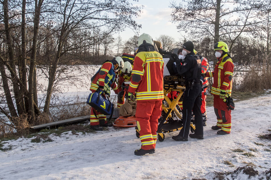 Rettungskräfte stehen an dem See.