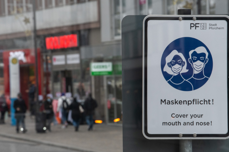 in Schild weißt in der Pforzheimer Innenstadt auf die Maskenpflicht hin.