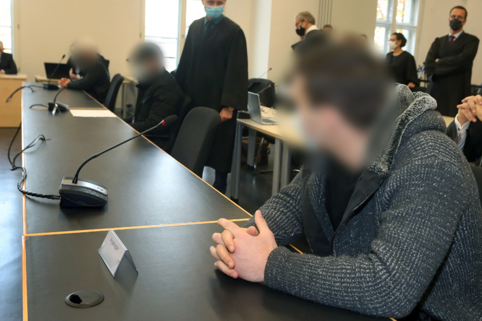 Der Hauptangeklagte (r.) sitzt im Gerichtssaal des Augsburger Landgerichtes neben den zwei Mitangeklagten. (Archivbild)