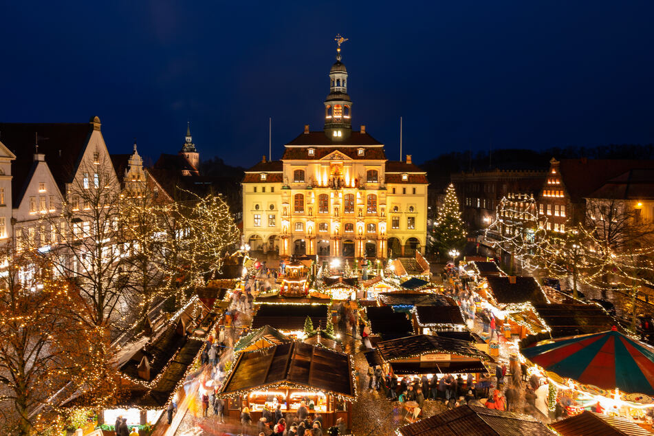 Besucher gehen über den Weihnachtsmarkt vor dem Rathaus der Stadt Lüneburg.