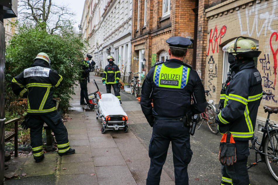 Rettungskräfte stehen vor einer Trage.