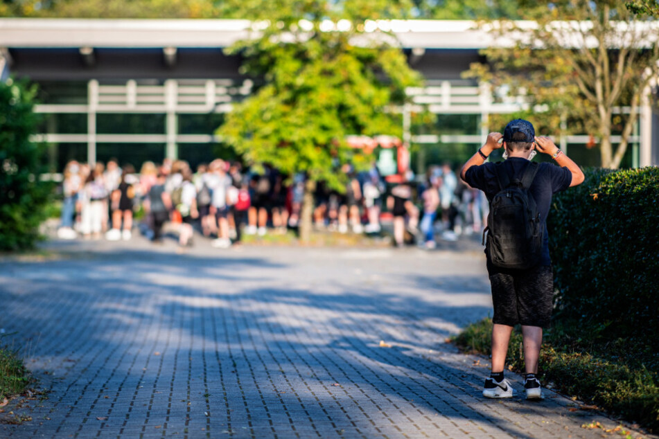 Nordrhein-Westfalen, Warendorf: Ein Schüler bindet sich am 1. Schultag nach den Sommerferien auf dem Weg zur Städtischen Gesamtschule in Warendorf einen Mund- und Nasenschutz um.