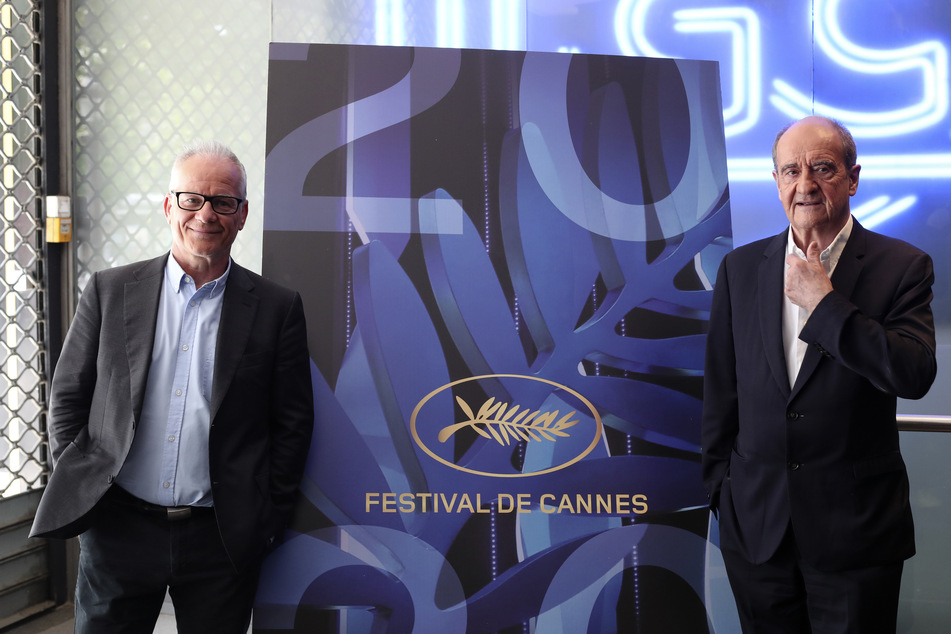 Festivalleiter Thierry Frémaux (l) und Festivalpräsident Pierre Lescure stehen vor einem Banner des "Festival de Cannes". Das Filmfest Cannes ist in diesem Mai wegen der Corona-Krise zwar ausgefallen, trotzdem haben die Organisatoren ihre Arbeit fortgesetzt und ein Programm mit 56 Filmen aufgestellt.