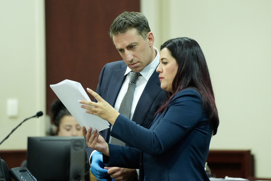 (L-R) Alex Spiro and Heather LeBlanc, attorneys for actor Alec Baldwin, look over paperwork during Baldwin's trial on involuntary manslaughter in First Judicial District Court on Friday in Santa Fe, New Mexico.