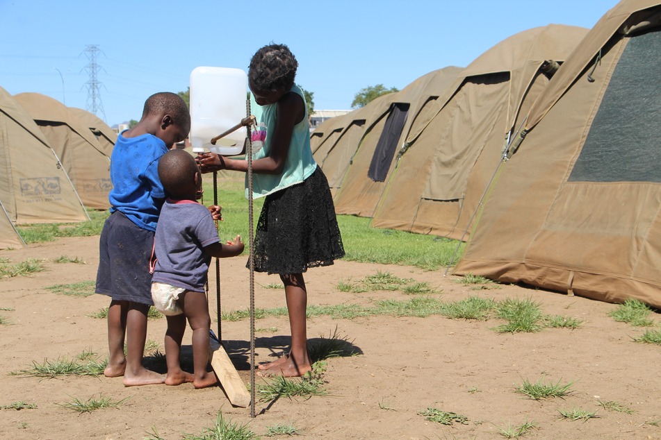 Kinder waschen sich an einer Notunterkunft in Namibia die Hände. Fließendes Wasser gibt es hier nicht.