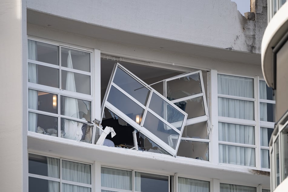 Ein zerbrochenes Fenster und ein beschädigtes Dach sind am Double Tree by Hilton Hotel zu sehen.