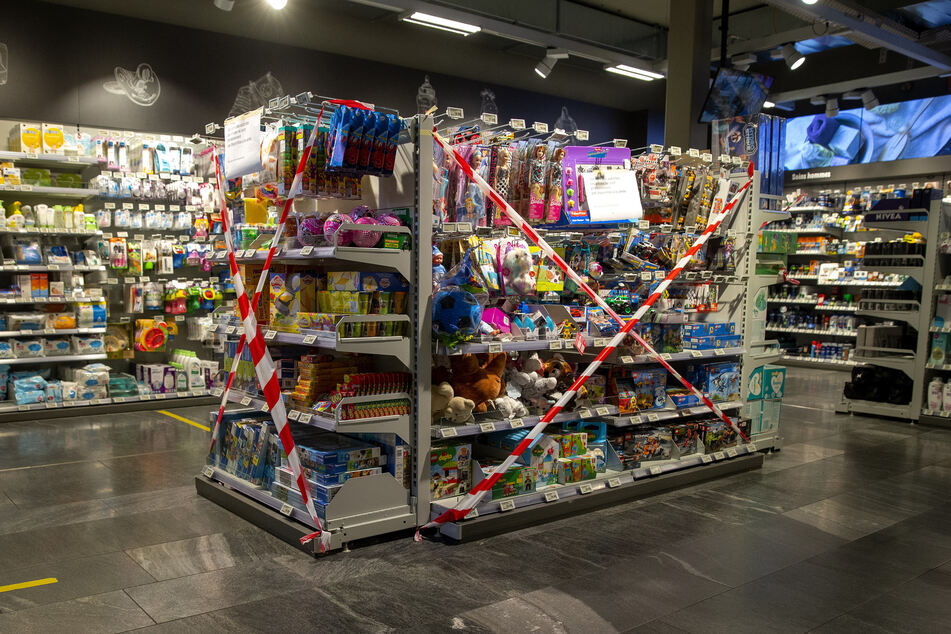 Ein Regal mit Spielzeug, also nicht-essentiellen Waren, ist in einem Supermarkt in der Schweiz mit Flatterband abgesperrt. So soll es wohl auch bald bei uns aussehen.