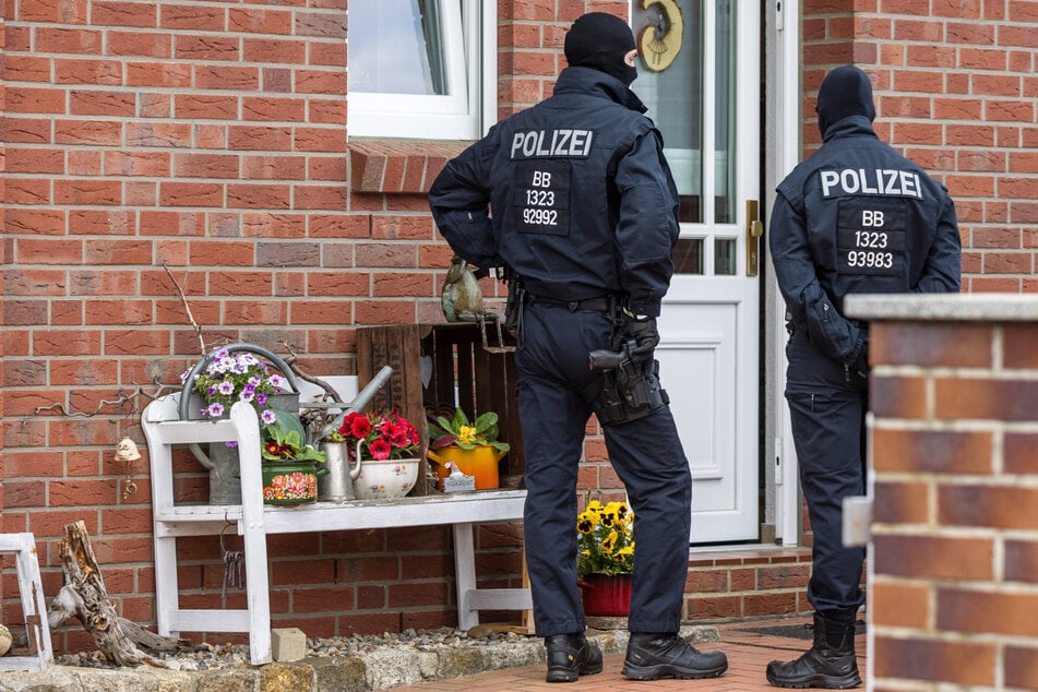 Schwer bewaffnete Polizisten holen die Verdächtigen ab.