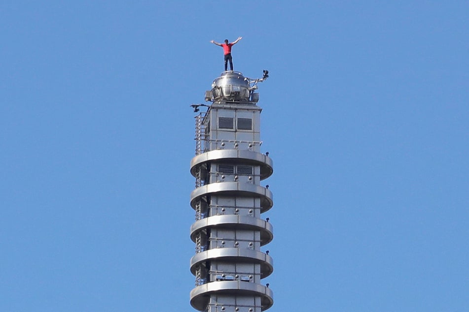 Honnold hebt die Hände, nachdem er ohne Sicherung auf den Wolkenkratzer Taipei 101 geklettert ist.