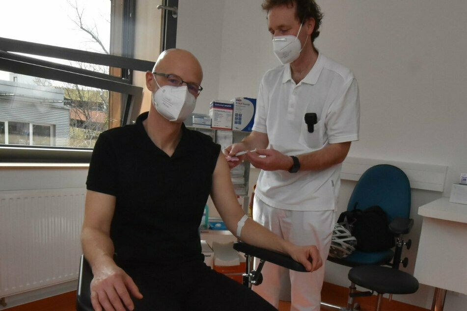 Prof. Gunnar Folprecht (r.), Leiter des Fachbereichs Onkologie des Uniklinikums Dresden, impft Peer Schmidt.