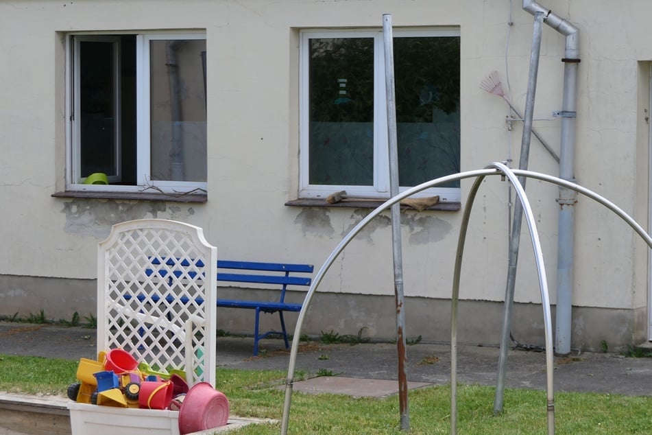 Der Putz bröckelt von der Wand und Risse zieren die Fassade der alten Kita.