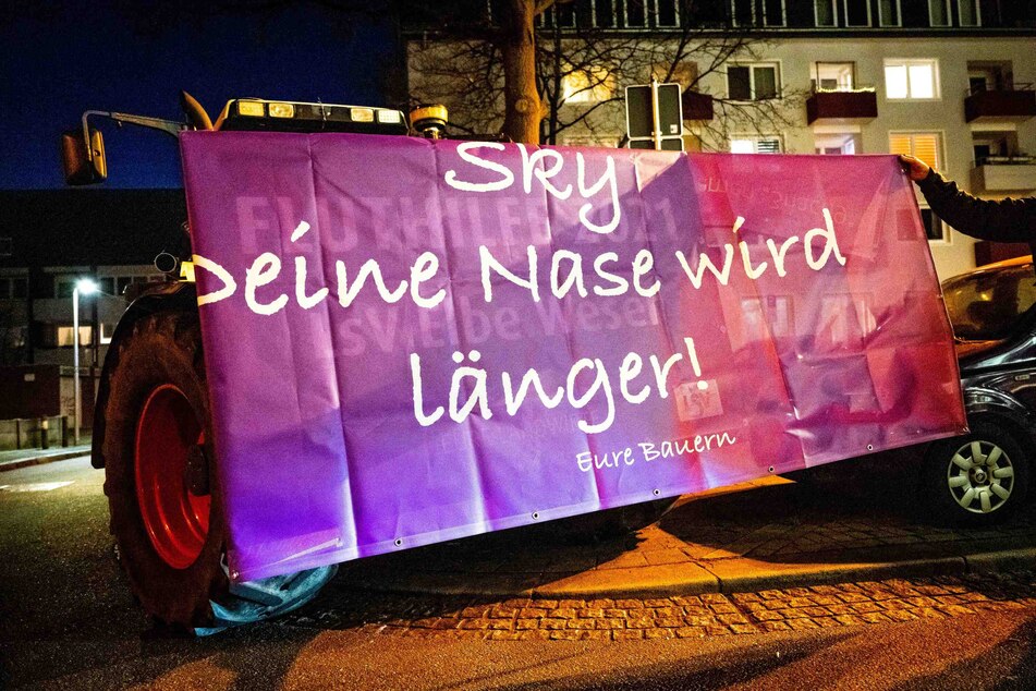 Ein Traktor mit einem Plakat mit der Aufschrift "Sky - deine Nase wird länger!" steht vor dem Funkhaus von Radio Bremen.