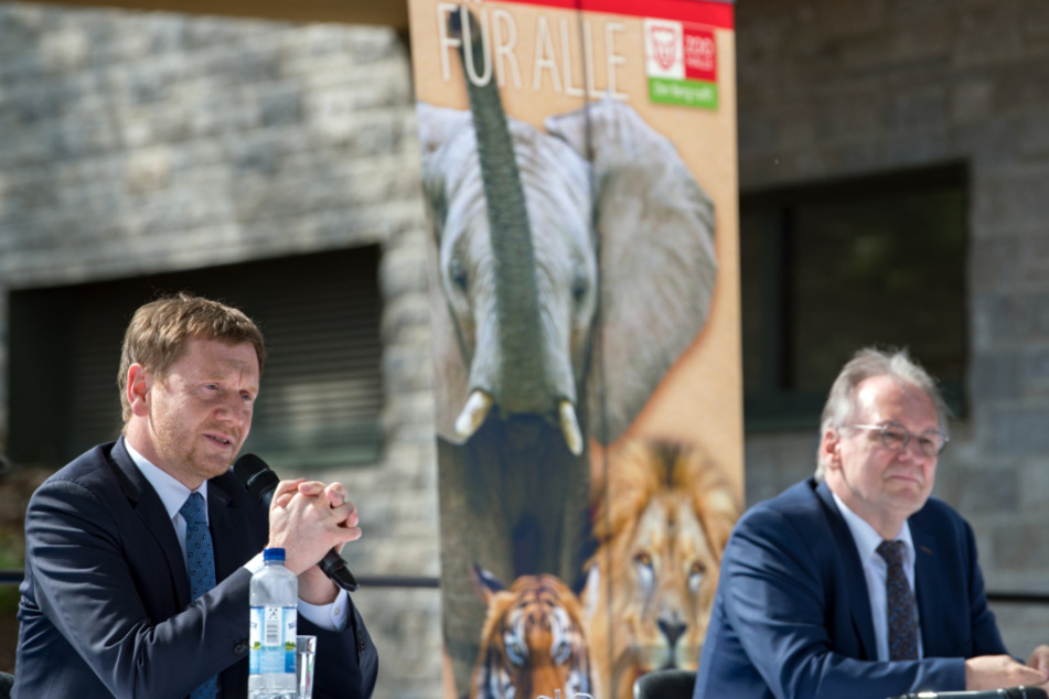 Michael Kretschmer and Reiner Haseloff during a press conference at the mountain zoo in Halle / Saale in front of a poster with elephant, lion and tiger.