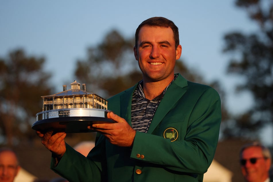 Scottie Scheffler with his first-career green jacket and the Masters trophy.