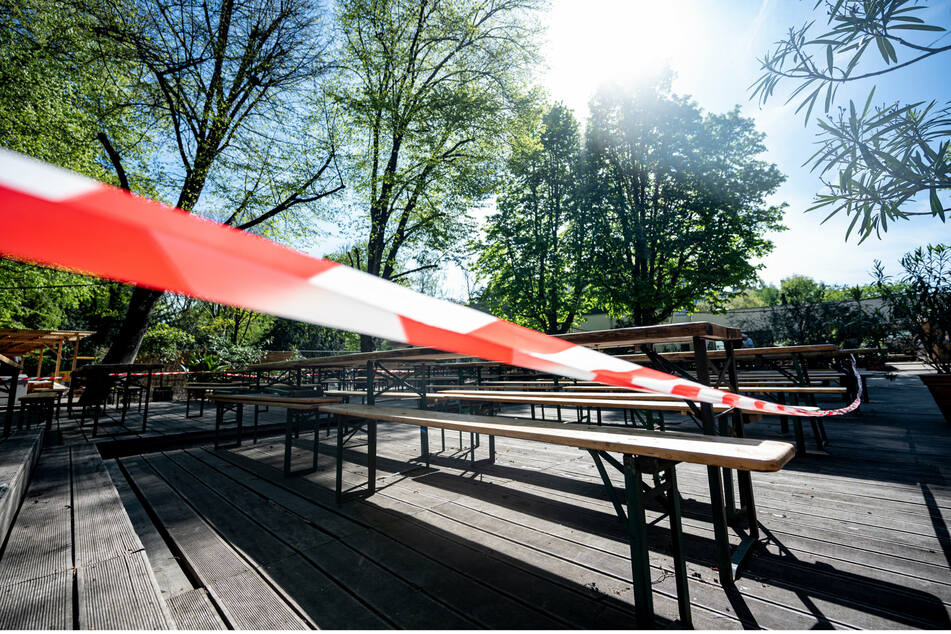 Ein rotes Band sperrt in einem geschlossenen Biergarten im Tiergarten den Außenbereich ab.