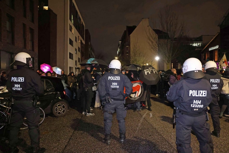 Demonstranten stehen behelmten Polizisten gegenüber. Die Lage vor Ort sei friedlich.