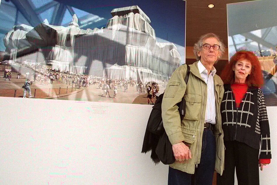 Christo (†84) und Jeanne-Claude (†74) im Januar 2002 bei einer Ausstellung in Washington. Links im Bild ist der verhüllte Reichstag im Original zu sehen.