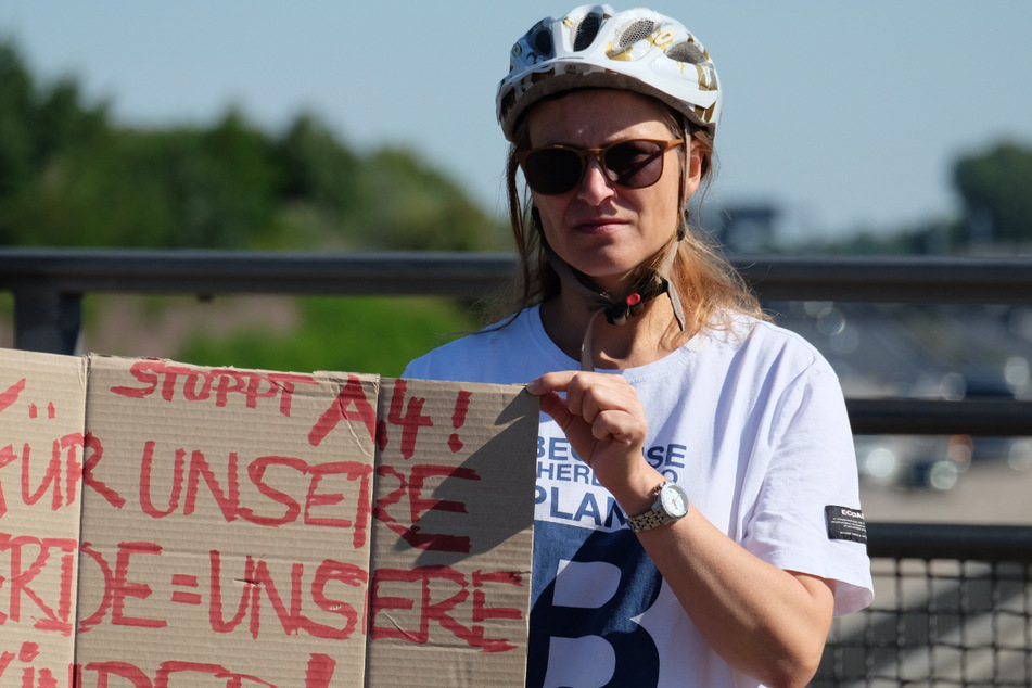 Eine Teilnehmerin hält ein Transparent auf der Autobahn-Überquerung.