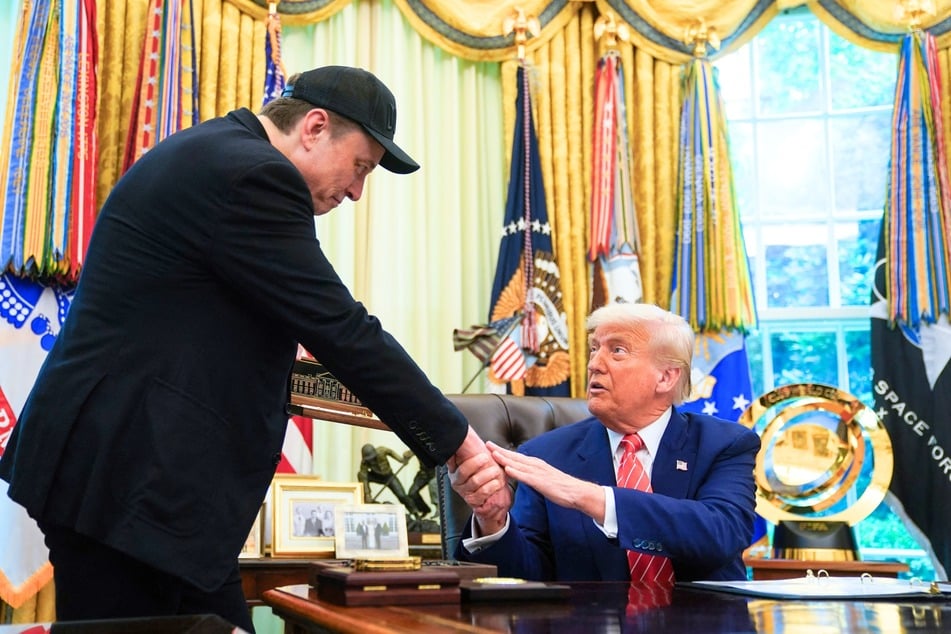 President Donald Trump (r.) shakes hands with Elon Musk (l.) after Trump gifted him with a "key to the White House" during a news conference in the Oval Office of the White House in Washington DC on May 30, 2025.