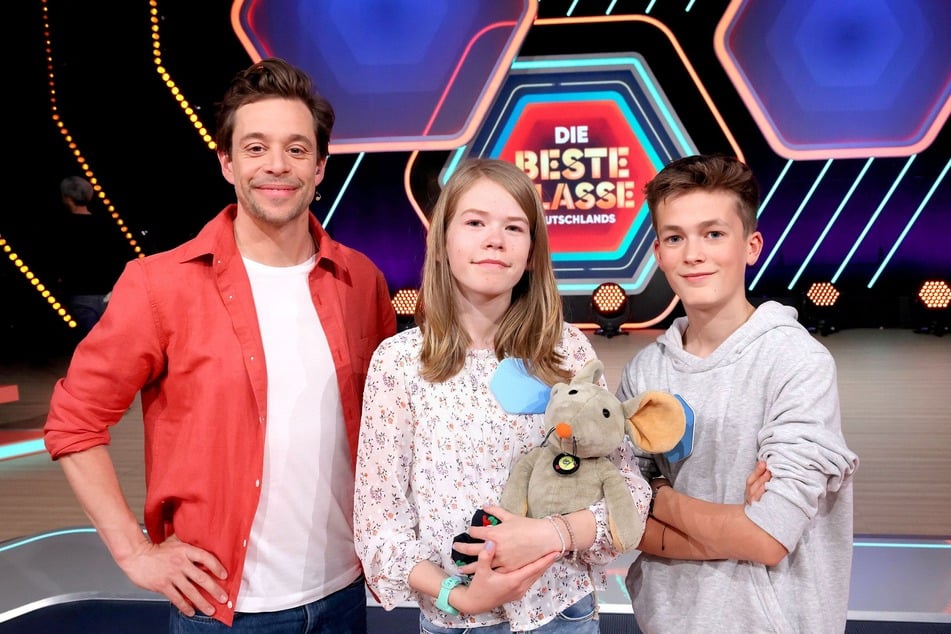 Anabelle (12, M.) und Jannis (13, r.) waren zusammen mit ihrer Klasse bei Moderator Tobias Krell (38) im KiKA-TV-Studio.