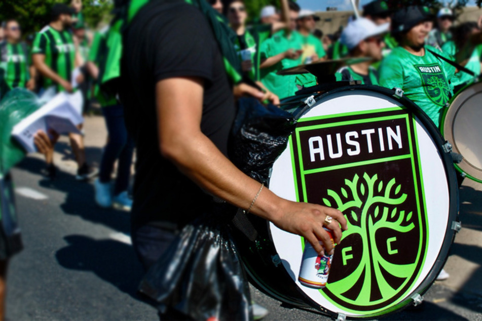 Austin FC fans march to Q2 stadium alongside La Murga de Austin on game day.