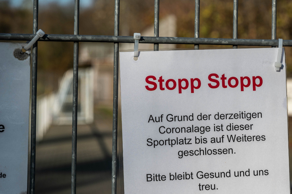 Ein Schild mit der Aufschrift "Stopp Stopp" hängt am Zaun des Fußballplatzes. Die Corona-Pandemie hat den Vereinssport stark getroffen. Gemeinsame Trainingseinheiten sind seit Monaten verboten.