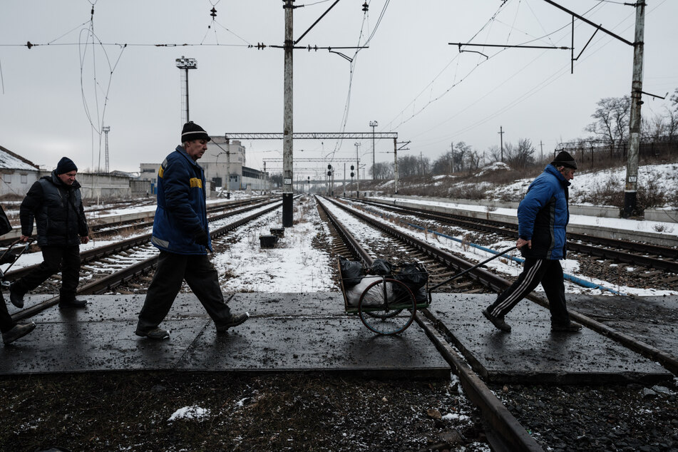 People pass by railway tracks as Russia's attack on Ukraine continues.