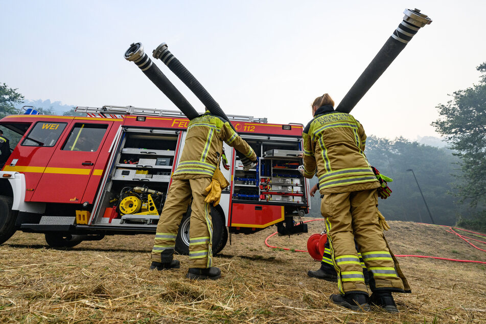Feuerwehrleute arbeiten am Elbufer in Schmilka an der Löschwasserversorgung im Kampf gegen die Waldbrände im Nationalpark Sächsische Schweiz.