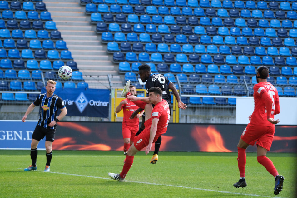 Joseph Boyamba (M.) erzielt das 1:0 für Waldhof Mannheim per Kopf im Duell mit Jozo Stanic vom FSV Zwickau.