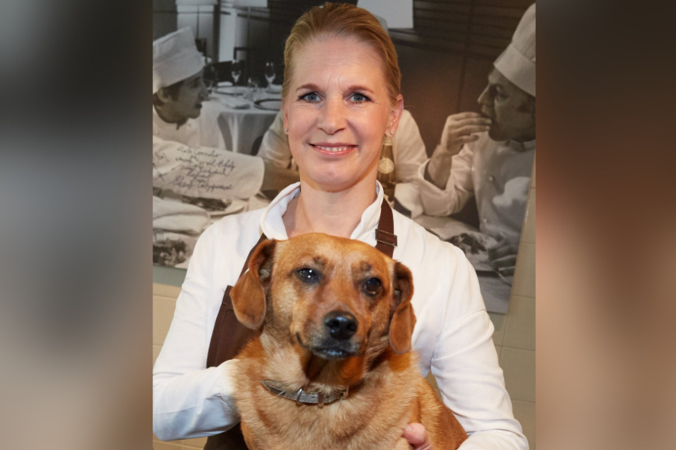 Die Spitzenköchin Cornelia Poletto steht während eines Pressetermins neben ihrem Hund Franz.