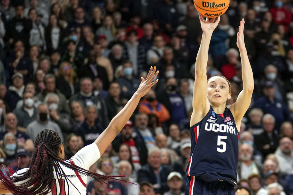 Paige Bueckers (r) scored 15 of her game-high 27 points in overtime to help UConn beat NC State.