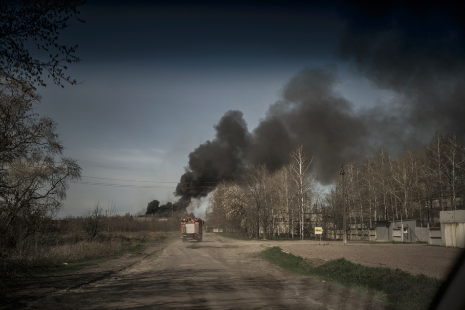 Feuerwehrleute fahren zu einem Brand in einer Fabrik nach einem russischen Angriff in den Außenbezirken von Charkiw.