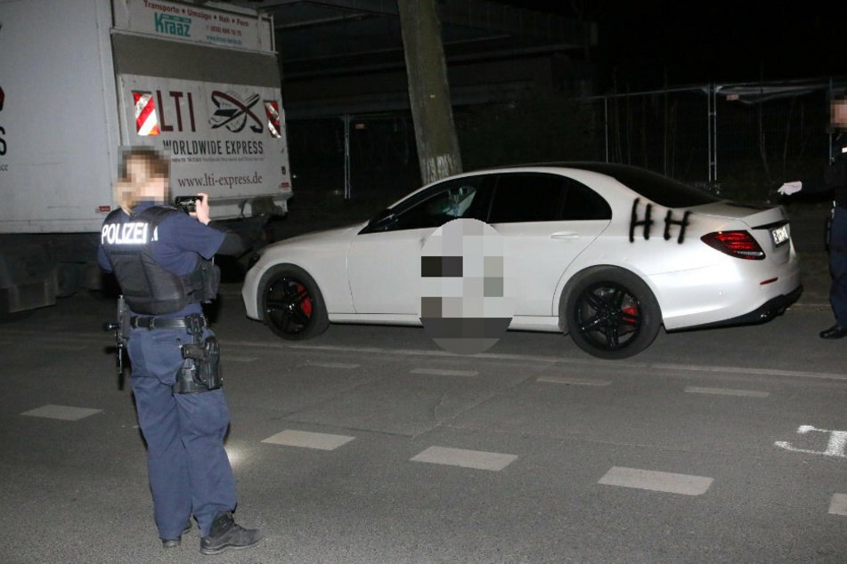 Eine Polizistin fotografiert das beschmierte Auto.